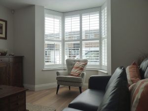 Angled Bay Window In Lounge With White Shutter Blinds