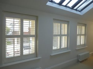 Three Window With White Plantation Shutters