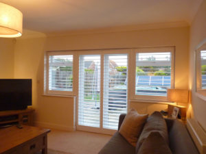 White Louvered Shutters On French Doors And Windows