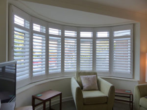 White Louvered Shutters On Large Round Bay Window