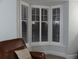 White Louvered Shutters In Angled Bay Window