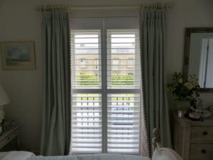 White Shutters With Green Curtains On Bedroom Doors