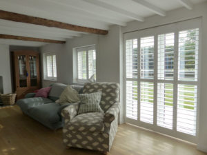 White Wooden Shutters On Patio Doors And Two Windows