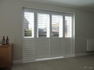 White Louvered Shutters With Bottom Louvers Closed On Patio Doors