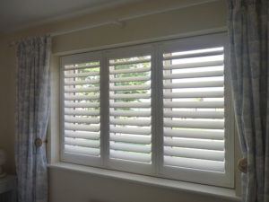 White Shutter Blinds With TPosts And Curtains Either Side