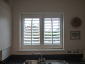 White Shutters In Small Kitchen Window Above Sink